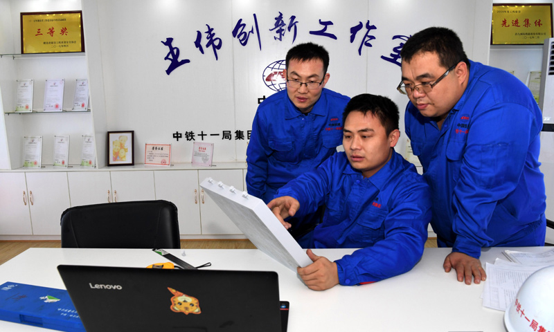 昌贛（南昌至贛州）客運(yùn)專線，又名昌贛高鐵，總長約415.2公里，是規(guī)劃中京九客運(yùn)專線的重要組成部分，設(shè)計(jì)行車速度為350公里/小時。在昌贛高鐵客運(yùn)專線工程建設(shè)中，有一批年輕的技術(shù)骨干，他們將國內(nèi)外的工作經(jīng)驗(yàn)和先進(jìn)的管理理念運(yùn)用到工作中，他們就是中鐵十一局橋梁公司王偉創(chuàng)新工作室。圖為2018年1月22日，王偉（中）和創(chuàng)新團(tuán)隊(duì)成員在研究改進(jìn)CRTSⅢ型先張法軌道板的預(yù)制工藝。（新華社記者 劉茜 攝）