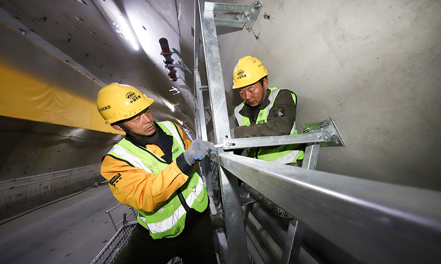 穿黃隧道盾構段龍骨骨架試拼的完成，解決了機電安裝中的消防噴淋與側墻龍骨骨架相互交叉的技術問題，避免了隧道內電焊施工過程中產生的焊煙等污染，同時，利用叉車替代人工加快了施工效率，為隧道后期順利通車奠定了堅實的基礎。圖為工人在隧道內進行龍骨骨架安裝。（范成濤 攝）
