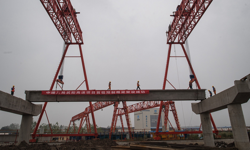 10月18日，由中建三局承建的武（武漢）陽（陽新）高速鄂州段二標首榀預制箱梁架設(shè)成功，全線施工加速推進。武陽高速起于武漢東湖高新區(qū)鳳凰山互通，止于陽新縣木港鎮(zhèn)。這條高速公路是武漢市東南通道的重要組成部分。圖為當日，來自中建三局的建設(shè)者在武陽高速鄂州段建設(shè)現(xiàn)場施工。（新華社記者 肖藝九 攝）