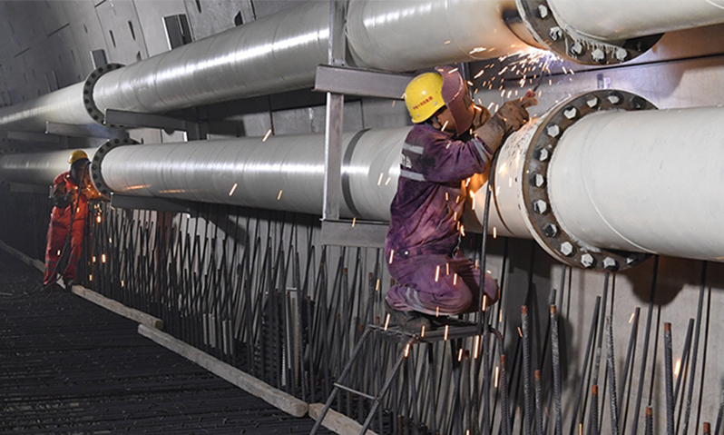 盾構機未加采石箱前，石塊在管道中橫沖直撞，給泥漿管道以破壞性打擊，10毫米厚的鋼板管道被磨穿，出漿管到處漏漿。盾構工作人員急中生智，將10米長的出漿管道旋轉180度使用，或使用加大壁厚的成型管道。其次，進漿管路和出漿管路互換，在管道接口加上一個彎頭，換道“行車”，進泥水廠前再加一處彎頭各歸各路。同時，立即找準磨損規律，在容易磨壞管道的位置，打“補丁”精準焊接鋼板。圖為電焊工對隧道內磨穿的泥漿管路進行補焊。