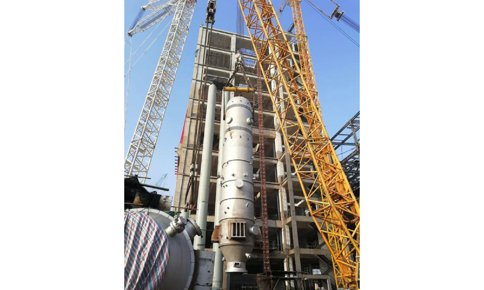 吊裝采用1600噸履帶吊作為主吊車，450噸履帶吊作為副吊車抬尾遞送，設備垂直后由1600噸履帶吊吊裝從氣化框架上部吊裝孔就位。圖為設備吊裝現場。