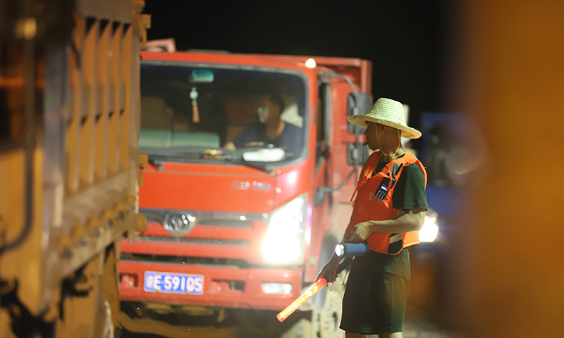 工作人員在施工現場調度車輛。