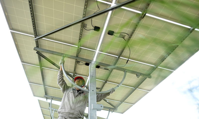 圖為7月8日，在青海省海南藏族自治州共和縣，大唐青海公司新能源分公司工作人員許源在光伏電站內調整光伏電池板角度。（新華社記者 張宏祥 攝）