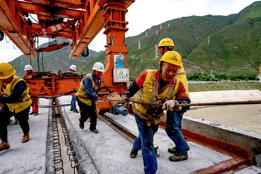 自今年3月復(fù)工以來，項(xiàng)目由安全、設(shè)備管理人員成立的安全監(jiān)察大隊(duì)，360度無死角地從T梁的制、裝、運(yùn)、架各環(huán)節(jié)進(jìn)行盯控，同時(shí)定期對作業(yè)人員進(jìn)行專項(xiàng)的安全技術(shù)交底和培訓(xùn)，確保施工過程中安全可控。圖為架梁隊(duì)員正在拖鋼軌。（丁慶濱 攝）