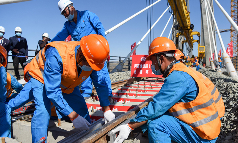 圖為7月2日，中鐵一局的施工人員在阿富準鐵路阿勒泰至富蘊段進行鋪軌作業。（新華社記者 丁磊 攝）