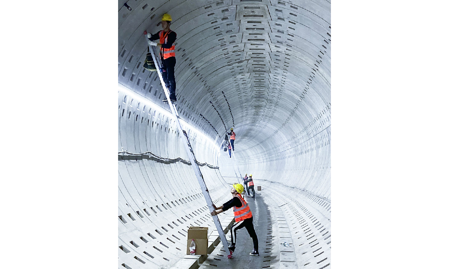 在通信、信號工程施工過程中，項目不斷采用國內(nèi)前沿的新技術新工藝，通過技術團隊科研攻關，在上海市軌道交通領域首次將LTE技術應用于地鐵通信系統(tǒng)。圖為工人在地鐵通信施工中進行漏纜卡具安裝。