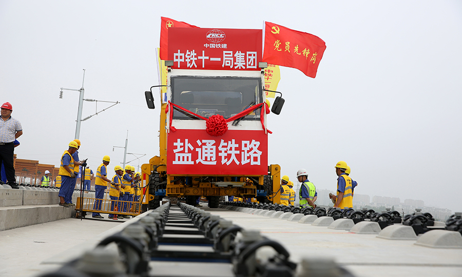 為確保鋪軌施工安全，中鐵十一局采用國(guó)內(nèi)領(lǐng)先的信息化綜合調(diào)度系統(tǒng)，可實(shí)現(xiàn)施工作業(yè)車(chē)輛實(shí)時(shí)衛(wèi)星定位、調(diào)度命令實(shí)時(shí)接收、超速報(bào)警、即時(shí)通訊等功能，在保障施工安全的同時(shí)，有效地提升了調(diào)度指揮能力和施工生產(chǎn)效率。圖為鹽通高鐵全線(xiàn)首鋪現(xiàn)。（彭特 攝）