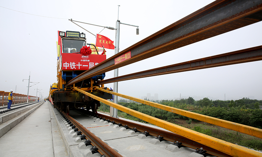 圖為作業(yè)人員操作鋪軌機(jī)進(jìn)行500米長(zhǎng)軌推送作業(yè)。（彭特 攝）