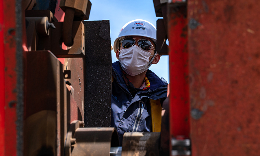 拉林鐵路無縫線路焊接的準(zhǔn)備工作自2019年5月就已經(jīng)開始。為了保證高原焊軌質(zhì)量，該項(xiàng)目部嚴(yán)格按照國家標(biāo)準(zhǔn)，編制了《焊軌、放散首件工程施工工藝試驗(yàn)》手冊，先后組織開展了工程線施工安全教育，焊軌、放散施工三級安全教育培訓(xùn)，質(zhì)量安全紅線管理規(guī)定宣貫學(xué)習(xí)以及焊軌、鎖定質(zhì)量培訓(xùn)。圖為技術(shù)人員正在調(diào)整焊軌機(jī)位置。（丁慶濱 攝）