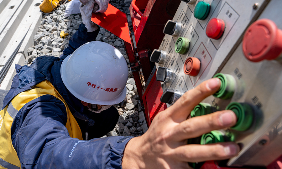 該項(xiàng)目部還增加了焊軌試驗(yàn)頻率，通過為期13天的焊機(jī)調(diào)整參數(shù)工作，經(jīng)過30根的落錘試驗(yàn)才最終確定了焊機(jī)工藝參數(shù)。送檢到鐵科院的22根焊接鋼軌，一次性通過鋼軌外觀、落錘、探傷、靜彎、疲勞、拉伸、沖擊、硬度、宏觀、顯微組織及晶粒度、斷口檢驗(yàn)等項(xiàng)目，型試試驗(yàn)報告均為合格。圖為技術(shù)人員正在調(diào)整焊軌機(jī)位置。（丁慶濱 攝）