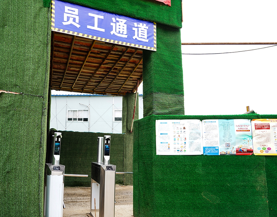 “攔住”張師傅的是中國鐵建所屬中鐵二十五局二公司南京仙林智谷項目部防疫檢測口新配備的刷臉設備?！爱敶蠹掖髦谡诌M入工區、項目部入口時，無須摘下口罩，和往常一樣刷臉就能通過門禁?！睋榻B，這個設備可對佩戴口罩后的人臉進行準確識別，驗證成功后,自動發出信號打開門禁或閘機，記錄考勤信息；對未佩戴口罩或口罩佩戴不規范人員，拒絕通過，并報警提示值班人員。圖為值守在員工通道上的人臉識別系統。（王云海 攝） 