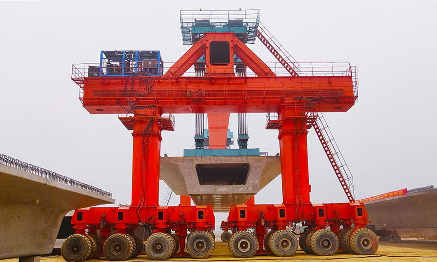 目前，漢壽制梁場已全面實現(xiàn)復工復產(chǎn)，未來將完成785孔箱梁預制任務。圖為漢壽制梁場全面配置了900噸級大型提梁機、運輸機和自動化噴淋養(yǎng)護設備，實現(xiàn)了箱梁全機械化轉(zhuǎn)運、保養(yǎng)維護。（靳林柱 攝）