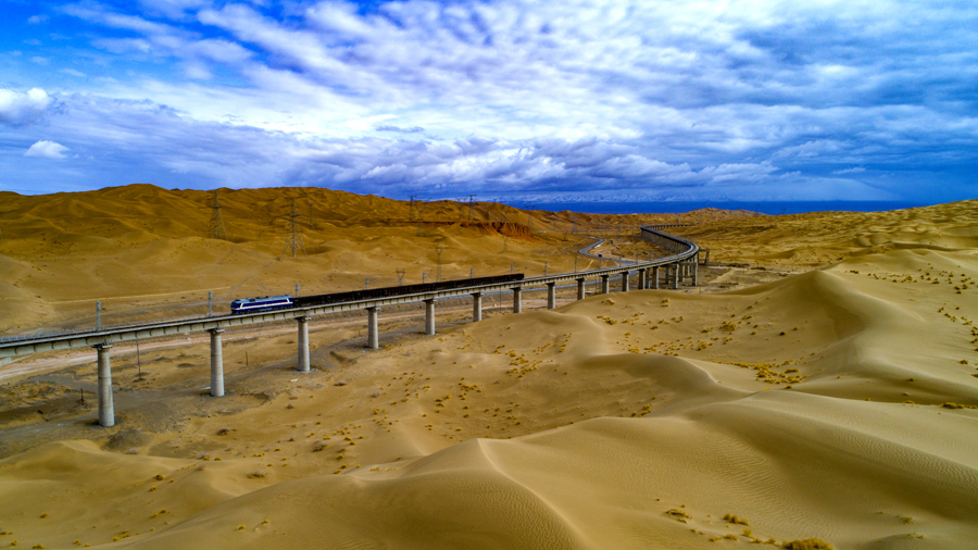 12月18日11時(shí)18分，一列火車緩緩開出格爾木站，標(biāo)志著由中國(guó)鐵建所屬鐵一院勘察設(shè)計(jì)，中鐵十一局、中鐵十二局、中鐵十七局、中鐵十九局、中鐵二十一局和中鐵二十二局參建的敦格鐵路全線通車運(yùn)營(yíng)。圖為一列火車在沙山溝特大橋上通行。（金偉 攝）