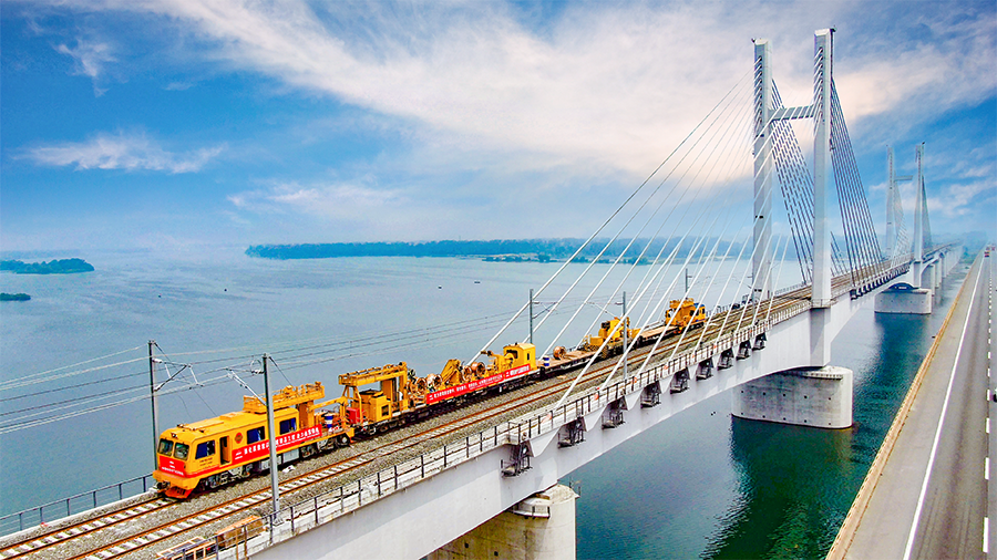 9月28日早上6時30分，首趟105節貨運列車滿載8400噸煤炭從浩勒報吉南站駛出，標志著世界上一次性建成并開通運營里程最長的重載鐵路——浩勒報吉至吉安鐵路（以下簡稱浩吉鐵路，即原蒙西至華中地區鐵路）開通運營。浩吉鐵路全長1813.5公里，北起內蒙古鄂爾多斯市浩勒報吉南站，終到京九鐵路吉安站。它的開通，改變了中國鐵路煤炭運輸格局，為我國鐵路版圖新增一條縱貫南北的能源運輸大通道。圖為中國鐵建電氣化局浩鐵路漢江特大橋上接觸網軌道車施工。