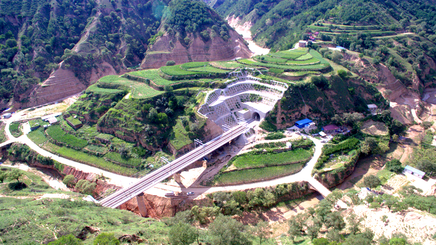 中國鐵建所屬鐵四院浩吉鐵路項目負責人介紹，浩吉鐵路設計時速120公里，開通初期開辦車站77座，規劃年運輸能力2億噸以上。按照設計要求，浩吉鐵路一次能牽引萬噸列車（約7600噸貨），開通后將實現一列車荷載108輛車廂的牽引動力。圖為中鐵十八局承建浩吉鐵路張家園隧道。（王強強 攝）