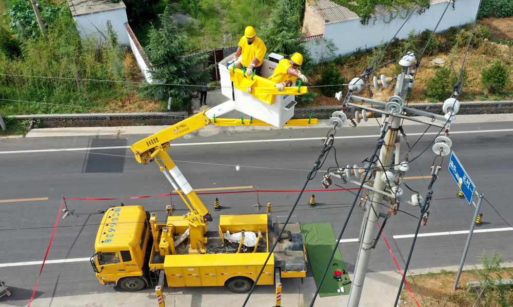 圖為7月30日，在河南省新安縣正村鎮上坡村，尤寧（左）和同事進行帶電作業。（新華社記者 馮大鵬 攝）　