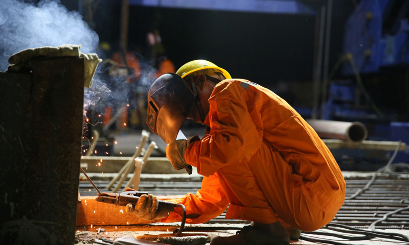 隨著最后一個(gè)合龍節(jié)段混凝土的澆筑，中老鐵路老撾瑯勃拉邦湄公河特大橋28日成功合龍，實(shí)現(xiàn)全橋貫通，比計(jì)劃工期提前7個(gè)月。圖為7月27日，中國中鐵八局工人在中老鐵路老撾瑯勃拉邦湄公河特大橋上焊接，為28日的合龍做準(zhǔn)備。新華社發(fā)（熊天澤 攝）