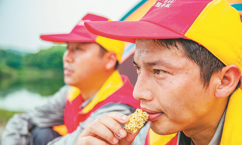 安徽省池州青陽山區(qū)特高壓密集通道的運檢工作，由國網(wǎng)安徽電力有限公司送變電工程公司運檢站36名工作人員承擔(dān)。圖為巡檢過程中，工作人員吃干泡面充饑。