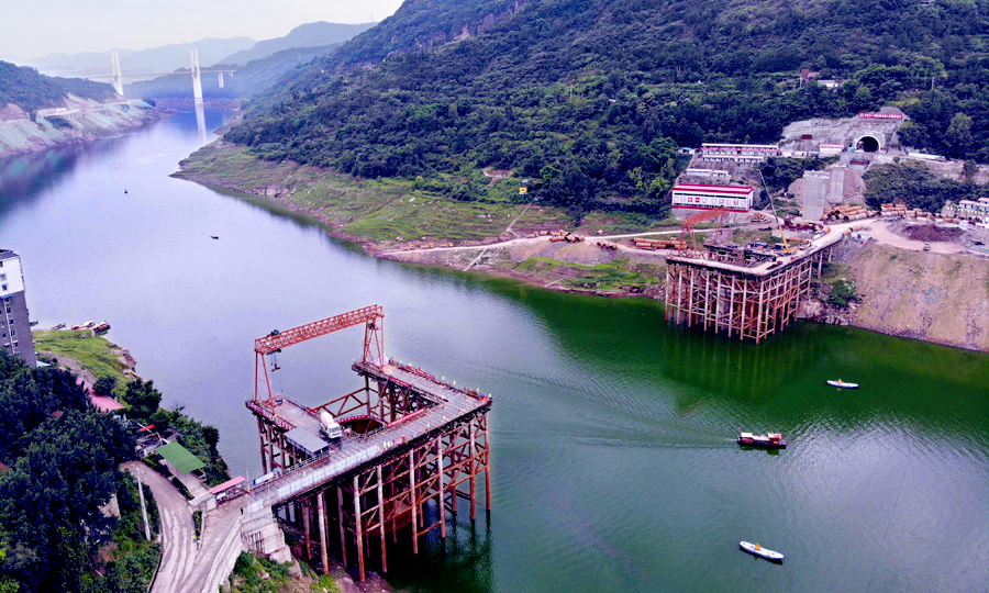 彭溪河多線特大橋位于重慶市云陽縣黃石鎮，由中國鐵建所屬中鐵十一局集團承建，大橋跨越長江一級支流彭溪河，橋長741.6米，共14跨。其10號和11號兩個主墩處于河段最高水深約60米的斜巖環境里。主墩橫穿三峽三期蓄水庫區，有三級通航要求，通航水位落差達30多米。圖為無人機拍攝的彭溪河多線特大橋施工現場。（劉興敏 攝）