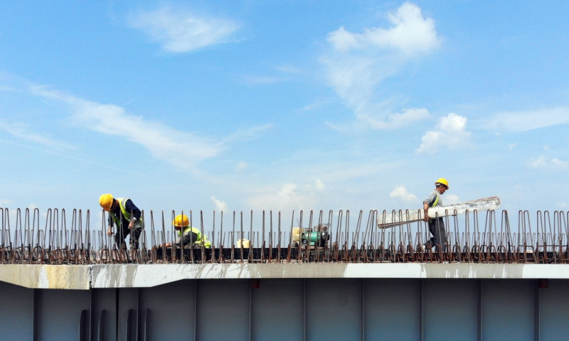 長(zhǎng)春連日來持續(xù)高溫。為確保京哈高速長(zhǎng)春至拉林河段改擴(kuò)建工程按期完工，中國(guó)交通建設(shè)股份有限公司的千余名筑路工人冒著高溫，奮戰(zhàn)在熱浪滾滾的一線工地，加緊進(jìn)行路基、路面、橋涵和環(huán)保綠化等工程施工。圖為7月9日，工人在京哈高速長(zhǎng)春至拉林河段改擴(kuò)建工程現(xiàn)場(chǎng)施工。（新華社記者 林宏 攝）