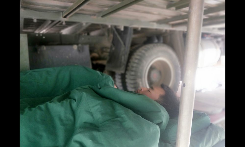 目前，中國(guó)安能第三工程局工作人員已奮戰(zhàn)多日，他們不僅晝夜施工，每天二十四小時(shí)兩班倒，還要在山里與烈日、冰雨和風(fēng)沙抗?fàn)帲c蚊蟲戰(zhàn)斗。他們不怕吃苦、不畏艱難，用實(shí)際行動(dòng)展現(xiàn)了央企的戰(zhàn)斗精神和過(guò)硬作風(fēng)。圖為6月21日，由于天氣炎熱，夜班人員倒班回來(lái)在車底下休息。