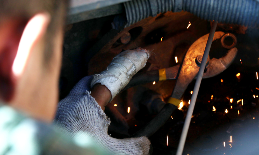 現(xiàn)場(chǎng)施工多半為臨水臨坡作業(yè)，在施工過(guò)程中，右岸滑坡體隨時(shí)有垮塌風(fēng)險(xiǎn)，滾石等經(jīng)常滑落，加之需夜間施工，危險(xiǎn)系數(shù)較高。圖為6月24日，修理工人左手受傷，仍堅(jiān)守工作崗位。（李明 攝）