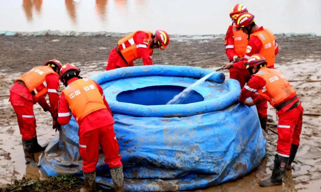 圖為搶險(xiǎn)隊(duì)員正在采用充氣式圍井緊急處置突發(fā)管涌險(xiǎn)情。