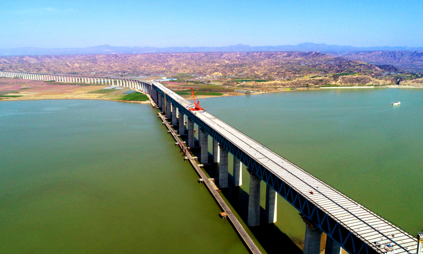 三門峽黃河公鐵兩用大橋主橋為下層四線鐵路與上層六車道高速公路結構。上層公路橋面系采用先張法預應力混凝土橋面板，橋面板與公路橫梁及上弦桿上布置的剪力釘通過濕接縫澆筑結合成整體。圖為三門峽黃河公鐵兩用大橋公路橋面板架設遠景。