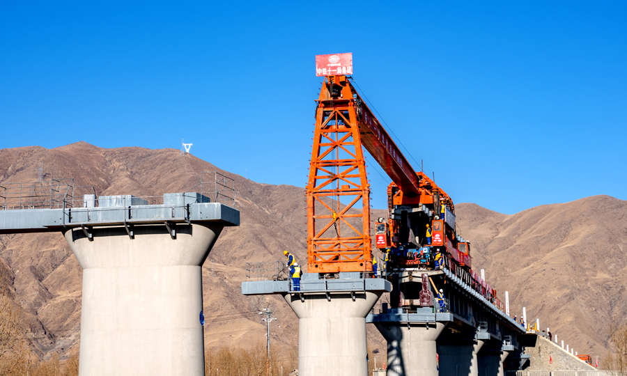 川藏鐵路是國家“十三五”規(guī)劃重點(diǎn)項(xiàng)目，也是繼青藏鐵路之后，“世界屋脊”通往內(nèi)地的又一條大動脈。據(jù)了解，川藏鐵路拉薩到林芝段是西藏第一條電氣化鐵路，正線全程435.48公里，總投資366.74億元，設(shè)計(jì)時速160公里，預(yù)計(jì)2021年建成通車。中鐵十一局三公司承擔(dān)著全線的鋪軌架梁任務(wù)。圖為杰德秀1號特大橋（拉林鐵路首座聲屏障特大橋）架設(shè)中。