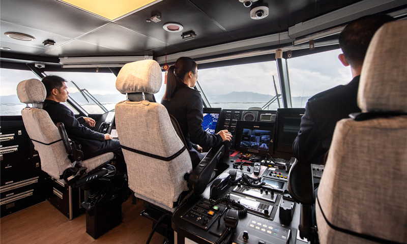 由于船體結(jié)構(gòu)特殊性，風(fēng)浪較大時(shí)，船舶產(chǎn)生的瞬時(shí)橫搖角度達(dá)到二十多度，對(duì)于駕駛員身體素質(zhì)有很高的要求。遇到濃霧或暴雨導(dǎo)致能見(jiàn)度不高，只能根據(jù)雷達(dá)屏幕顯示的海面情況操縱船舶，駕駛員的心理素質(zhì)也面臨著極大考驗(yàn)。何倩倩從小與海結(jié)緣，堅(jiān)韌樂(lè)觀。她總是迎難而上，以良好的心理素質(zhì)、熟練的駕駛技巧、敬業(yè)的工作態(tài)度將旅客安全送達(dá)。圖為迅隆7號(hào)高速客船駕駛艙。（唐蜀全 攝）