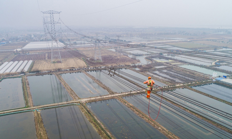 圖為2月1日，施工人員正在改接工程現場進行走線，巡查特高壓線路。（新華社記者 徐昱 攝）