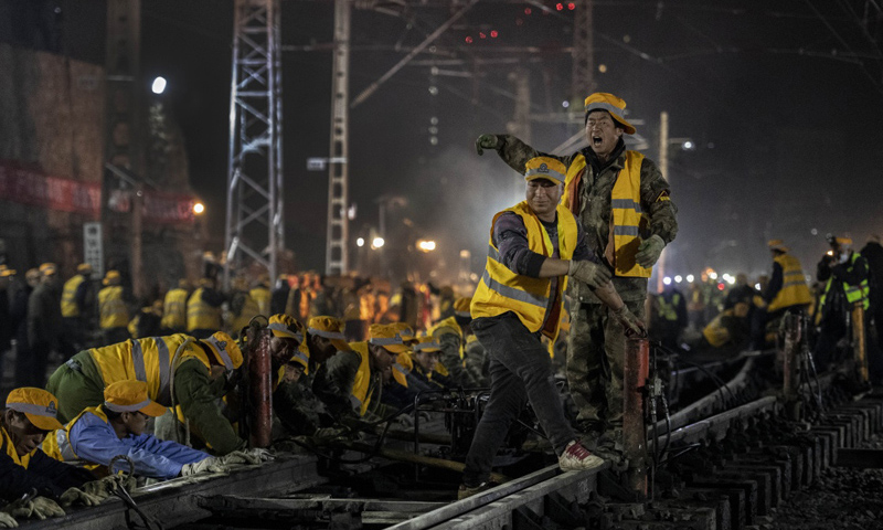 1月15日，經過中鐵十一局等參建各方1000余人6個多小時通宵奮戰，西安火車站改擴建工程首次聯鎖設備換裝施工圓滿完成，進入主體工程實施階段，為即將開始的春運旅客運輸提供堅實的基礎保障。圖為1月15日凌晨，中鐵十一局施工人員在西安站改擴建工程現場指揮軌道撥接。（新華社記者 陶明 攝）