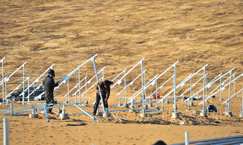 庫布其光伏治沙項目被稱為沙漠中的“太陽谷”，積極應用“治沙+種草+養殖+發電+扶貧”五位一體的復合生態太陽能治沙新模式，項目投產后，社會效益、生態效益、民生效益、經濟效益顯著，可實現治沙面積78000畝。運營周期內可幫扶貧困戶800余戶，創造就業機會1000余個，增加農牧民收入1900余萬元。圖為工作人員正在安裝光伏支架。