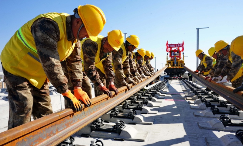 圖為11月1日，在京張高鐵河北懷來段鋪軌現(xiàn)場(chǎng)，中鐵三局的工人鋪下京張高鐵全線第一節(jié)軌排。（新華社記者 楊世堯 攝）