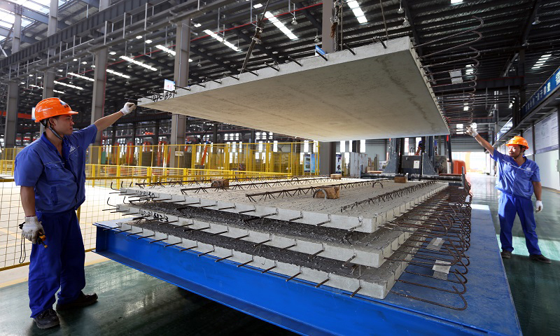 圖為建筑工人進(jìn)行“樓板”裝車(chē)。