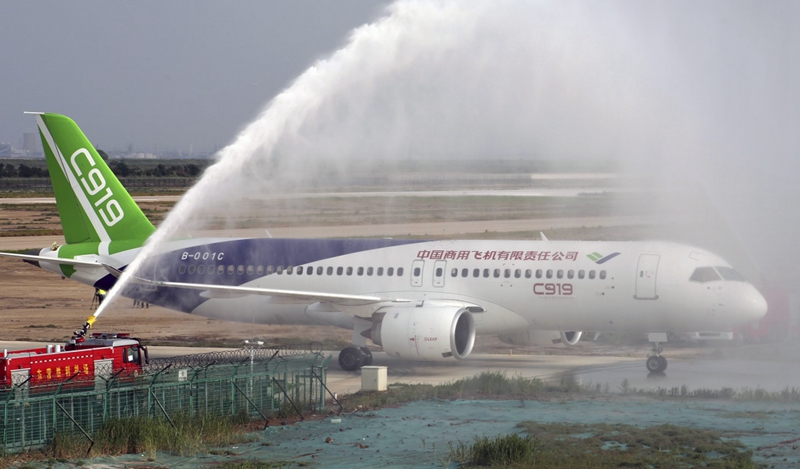 7月12日，在山東東營勝利機場，消防車噴射水柱迎接C919大型客機102架機。新華社發（周廣學 攝）