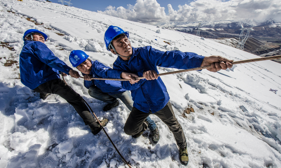 施工人員用力拉絞磨機牽引繩。（鄒熠霏 陳紅梅 攝）