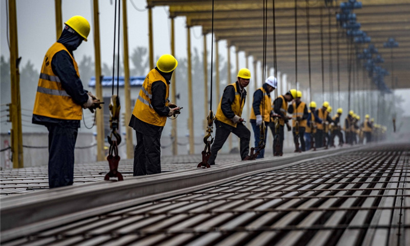 5月5日，中鐵十一局職工在漢十高鐵棗陽(yáng)鋪軌基地堆碼500米長(zhǎng)軌。（新華社記者 杜華舉 攝）
