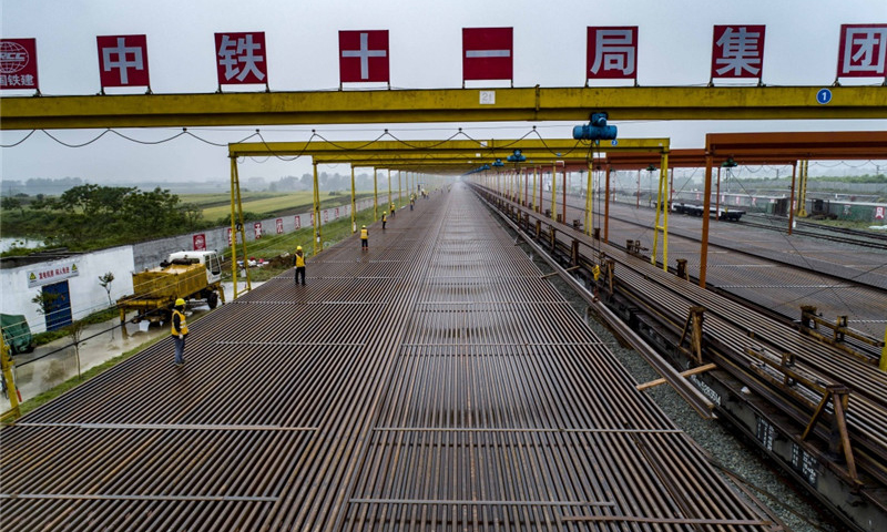 5月5日，中鐵十一局職工在漢十高鐵棗陽(yáng)鋪軌基地堆碼500米長(zhǎng)軌。（新華社記者 杜華舉 攝）