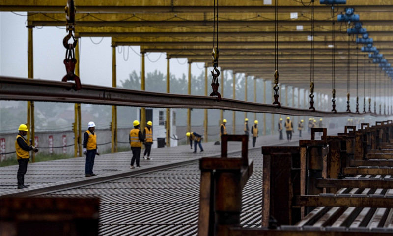 5月5日，中鐵十一局職工在漢十高鐵棗陽(yáng)鋪軌基地堆碼500米長(zhǎng)軌。（新華社記者 杜華舉 攝）