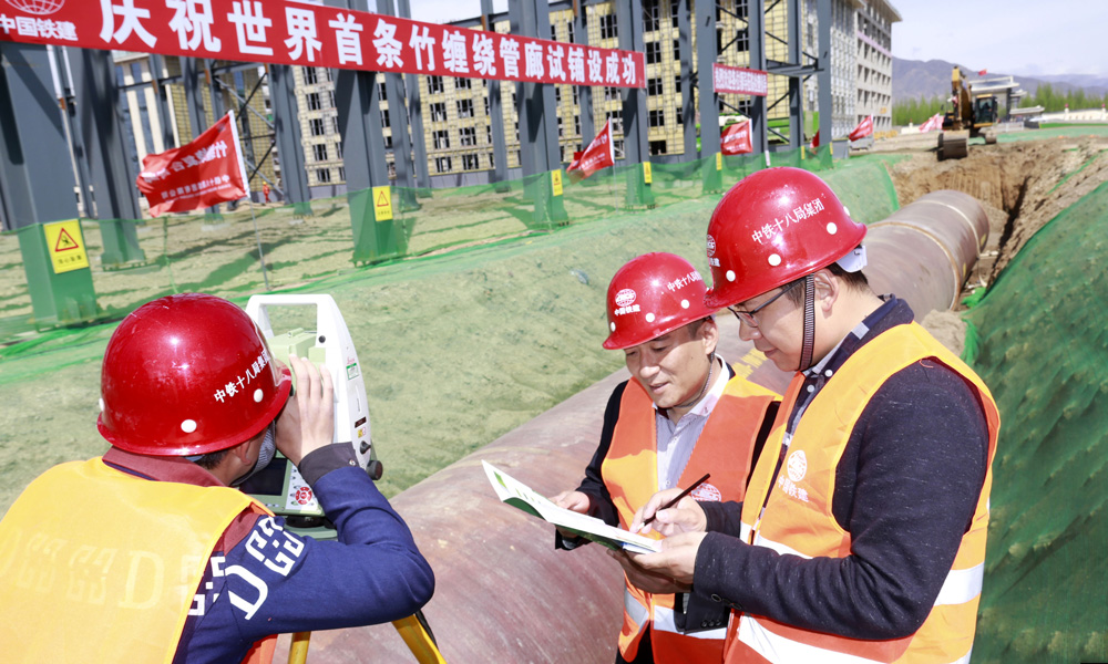 作為世界首創(chuàng)的新型城市地下管廊，竹纏繞城市綜合管廊是具有核心知識產(chǎn)權(quán)的“中國制造”產(chǎn)品，是國家《林業(yè)產(chǎn)業(yè)發(fā)展十三五規(guī)劃》的重點戰(zhàn)略林產(chǎn)項目和城市綜合管廊示范工程。圖為中國鐵建所屬中鐵十八局軌道公司項目經(jīng)理龍剛、項目書記宋鵬等在呼和浩特市元亨石墨產(chǎn)業(yè)園鋪設(shè)世界首條竹纏繞城市綜合管廊組織施工。（伍振 梁建剛 攝）