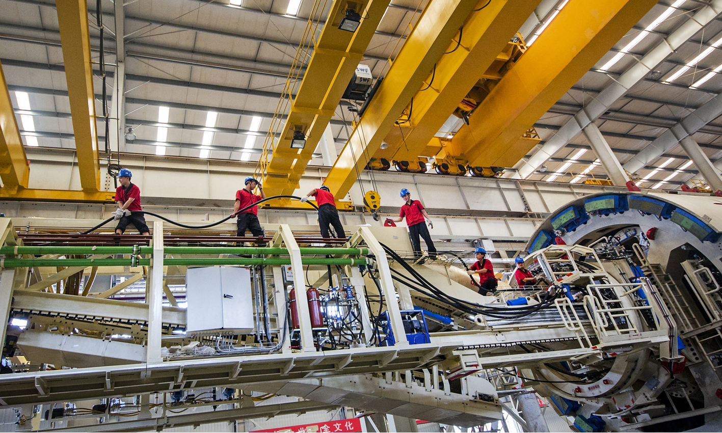 盾構機/TBM是一種集開挖、出渣及支護等功能于一體的大型隧道施工裝備，與傳統的隧道施工工法相比，盾構工法具有掘進速度快、隧道質量優、勞動強度低、地面擾動小等顯著優勢，已成為我國所有地下工程開挖及建設的首選工法。圖為中國鐵建重工集團員工一字排開，將電纜往目標位置輸送。