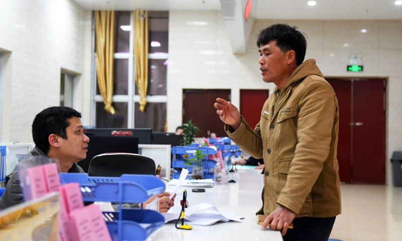 在廣西欽州港經濟技術開發區行政審批局，前來辦事人員（右）正在咨詢有關行政審批事宜。（新華社記者 陸波岸 攝）