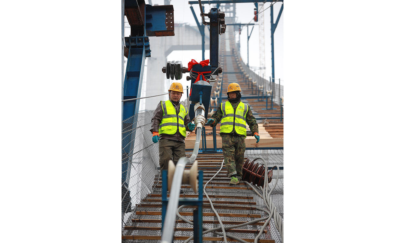 圖為1月5日，建設(shè)者們在開州湖特大橋建設(shè)工地進行主纜索股架設(shè)。（新華社記者 劉續(xù) 攝）