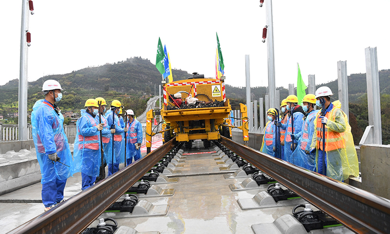 鄭萬高鐵是我國“八縱八橫”高速鐵路網(wǎng)中沿江通道和呼南通道的重要組成部分。線路起于河南省鄭州市，止于重慶市萬州區(qū)，新建線路全長約818公里，設(shè)計(jì)時(shí)速350公里。圖為3月1日，在鄭萬高鐵重慶段施工現(xiàn)場，施工人員進(jìn)行鋪軌前的準(zhǔn)備工作。(新華社記者 唐奕 攝)