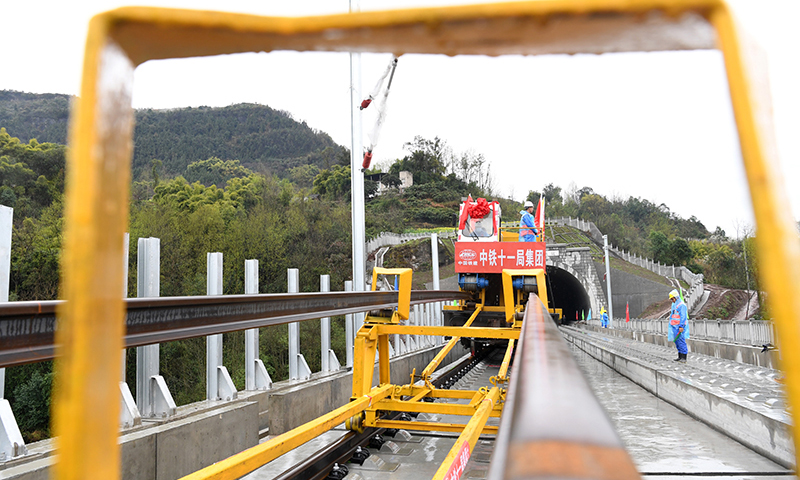 圖為3月1日，在鄭萬高鐵重慶段施工現(xiàn)場，鋪軌機(jī)進(jìn)行鋪軌前的準(zhǔn)備工作。(新華社記者 唐奕 攝)