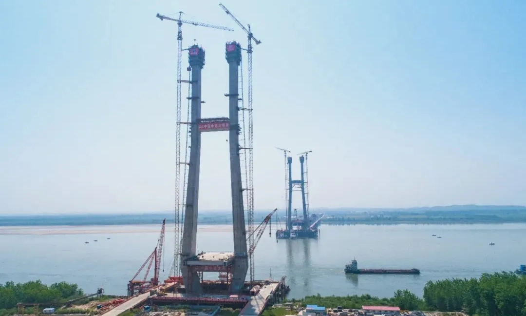 大橋主塔采用“H”形設(shè)計(jì)，北主塔高217.33米，南主塔高223米。建設(shè)者創(chuàng)新設(shè)計(jì)方式，攻克了大體積承臺(tái)混凝土澆注、超高主塔混凝土一次性垂直傳輸、大跨徑720米鋼混組合梁索力和成橋線型控制等多項(xiàng)世界難題。圖為大橋主塔封頂。