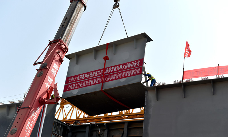 鎮(zhèn)羅黃河特大橋全長1289米，橋?qū)?6米，是銜接烏瑪高速公路和定武高速公路聯(lián)絡線的主要通道，同時也是全線的重點控制性工程。圖為4月11日拍攝的烏瑪高速公路鎮(zhèn)羅黃河特大橋合龍施工現(xiàn)場。（新華社記者 唐如峰 攝）