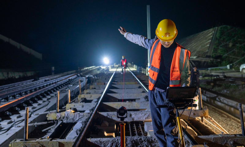 圖為4月12日晚，在湖北省南漳縣境內(nèi)的鄭萬高鐵南漳站，中鐵十一局技術(shù)人員對無砟軌道進行精調(diào)。（新華社記者 杜華舉 攝）