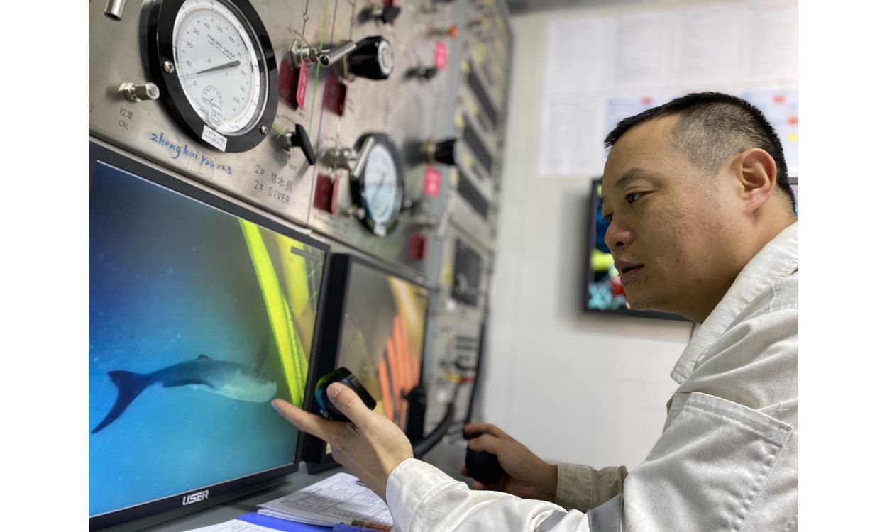 “十三五”期間，擁有最大一支“海油蛙人”團(tuán)隊(duì)的海洋石油工程股份有限公司技術(shù)服務(wù)分公司通過(guò)科研攻關(guān)、升級(jí)改造設(shè)備等舉措打造綠色海洋技術(shù)服務(wù)體系，在做好海洋能源開(kāi)發(fā)者的同時(shí)擔(dān)起海洋環(huán)境保護(hù)者的責(zé)任。過(guò)去5年，該公司完成5個(gè)項(xiàng)目的單點(diǎn)及導(dǎo)管架平臺(tái)拆除，總重量近6000噸；完成水下雜物清理約1176噸；通過(guò)引進(jìn)、推廣綠色清潔無(wú)損檢測(cè)高新技術(shù)，守護(hù)藍(lán)色海洋。圖為海上液化天然氣接收站項(xiàng)目水下作業(yè)過(guò)程中，監(jiān)控顯示一條大魚(yú)前來(lái)“圍觀”潛水員作業(yè)。